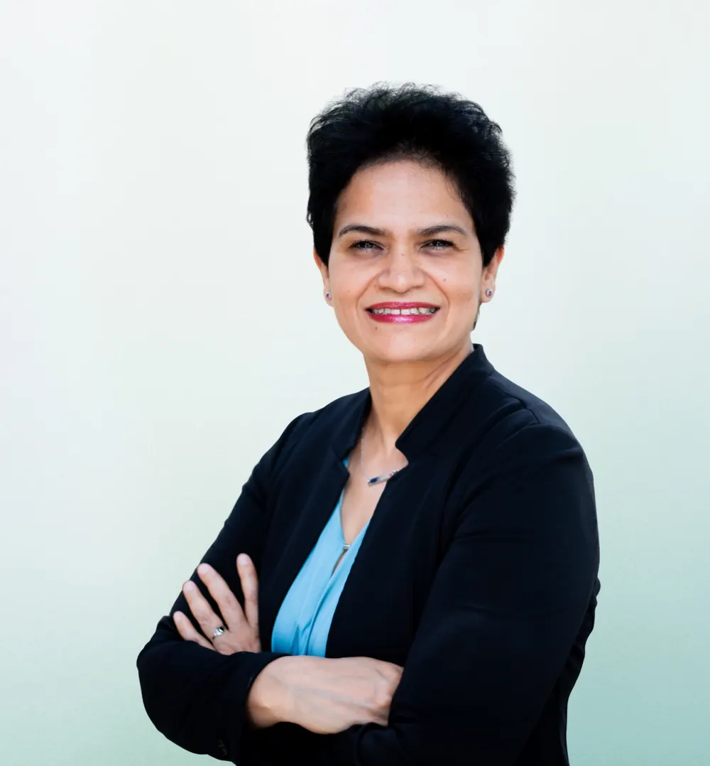 Dr. Hajira Yasmin, board-certified OB-GYN, smiling with arms crossed